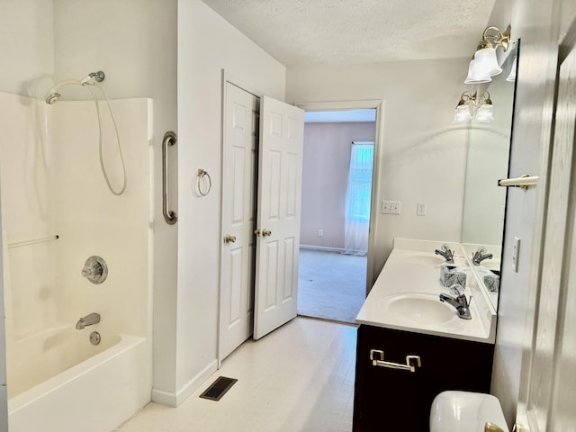 bathroom featuring vanity, shower / washtub combination, and a textured ceiling