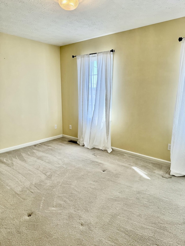 carpeted spare room with a textured ceiling