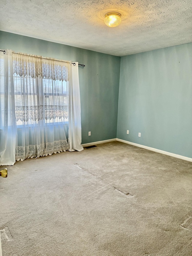 empty room featuring carpet flooring and a textured ceiling