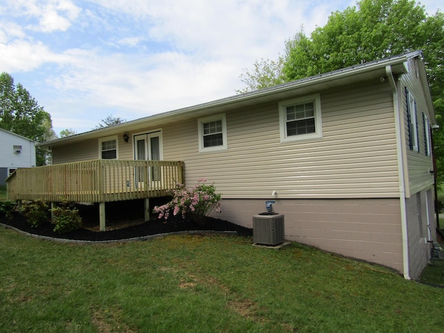 back of house featuring a wooden deck, central air condition unit, and a lawn