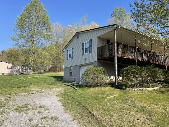 view of side of property featuring a garage, a lawn, and a deck