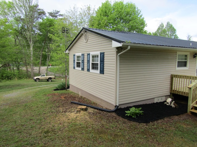 view of home's exterior with a yard, a deck, and metal roof