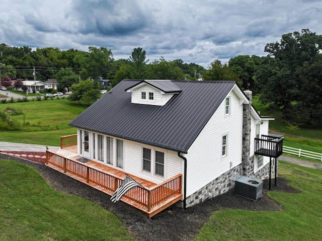 back of house with a lawn, a wooden deck, and central air condition unit