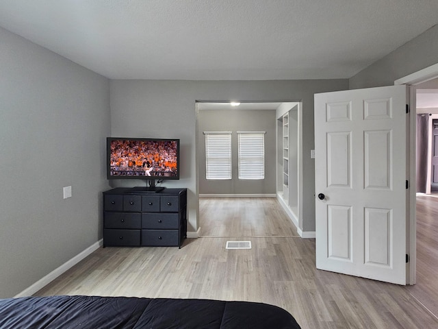 unfurnished bedroom with light hardwood / wood-style floors and a textured ceiling