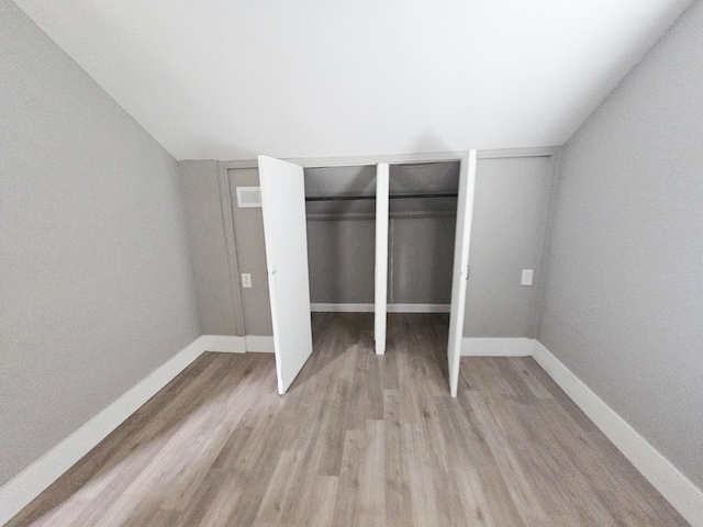 unfurnished bedroom featuring light hardwood / wood-style floors and a closet