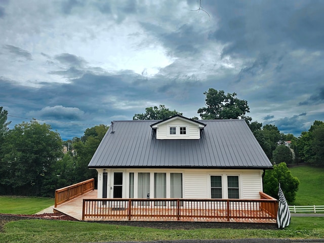 rear view of house featuring a deck and a lawn