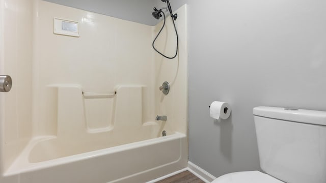 full bathroom featuring baseboards, wood finished floors, and toilet