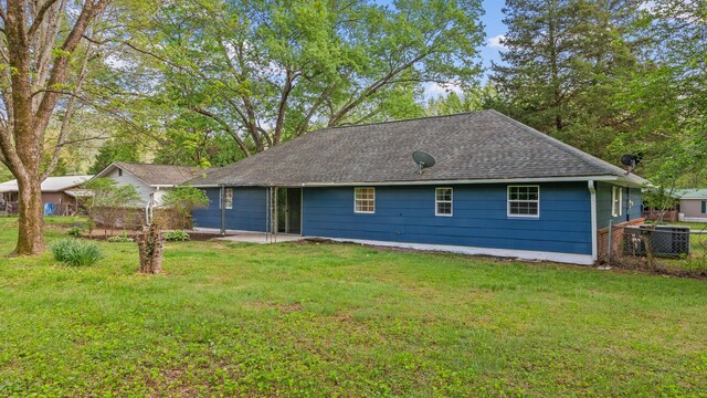 back of house featuring roof with shingles, fence, central AC unit, a patio area, and a yard
