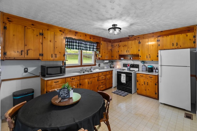 305 Hamilton Pl, Kingsport, TN 37663 - kitchen featuring freestanding refrigerator, electric stove, light countertops, brown cabinets, and a textured ceiling