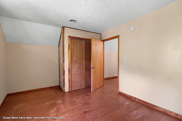 148 Delph Ln, Mooresburg, TN 37811 - unfurnished bedroom featuring wood finished floors, a textured ceiling, a closet, baseboards, and lofted ceiling