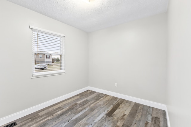 spare room with hardwood / wood-style floors and a textured ceiling