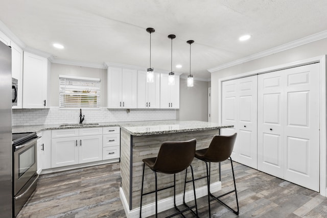 kitchen featuring white cabinetry, a center island, sink, and decorative light fixtures