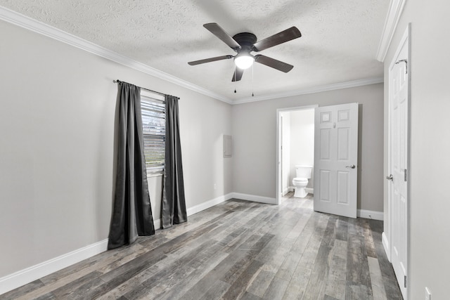 empty room featuring ornamental molding, dark wood-type flooring, a textured ceiling, and ceiling fan