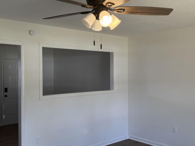 spare room featuring ceiling fan, dark hardwood / wood-style flooring, and a textured ceiling