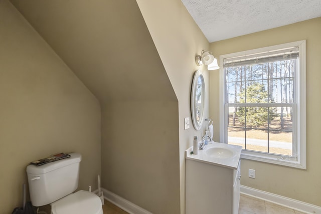 bathroom featuring vanity, toilet, plenty of natural light, and a textured ceiling