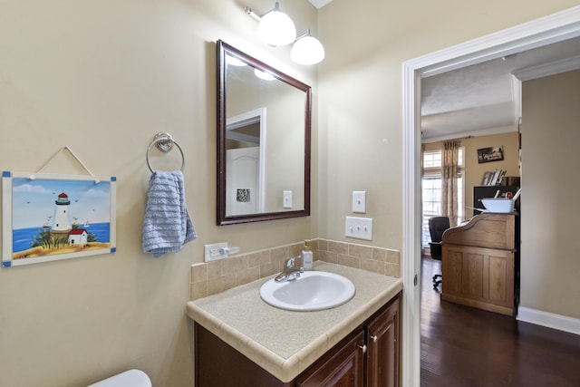 bathroom featuring hardwood / wood-style flooring, vanity, and crown molding