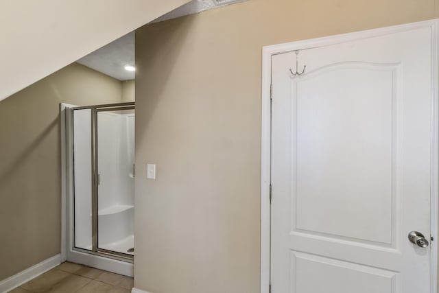 bathroom with tile patterned flooring and walk in shower