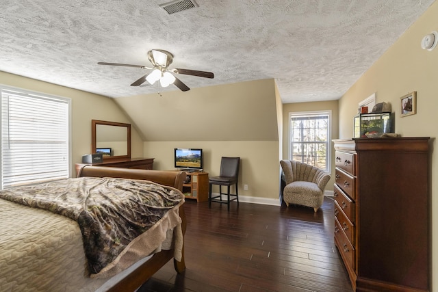 bedroom with a textured ceiling, dark hardwood / wood-style flooring, vaulted ceiling, and ceiling fan