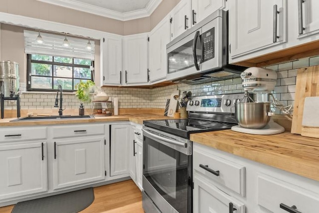 5700 Academy Dr, Morristown, TN 37814 - kitchen featuring appliances with stainless steel finishes, a sink, butcher block counters, ornamental molding, and white cabinetry