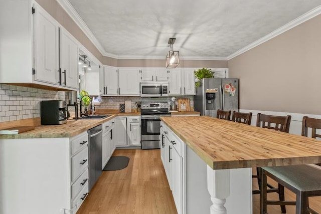 5700 Academy Dr, Morristown, TN 37814 - kitchen with appliances with stainless steel finishes, a sink, a kitchen breakfast bar, white cabinets, and crown molding