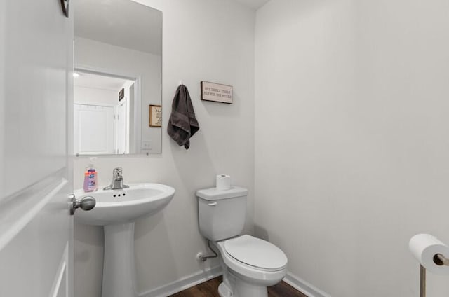 bathroom featuring wood-type flooring and toilet