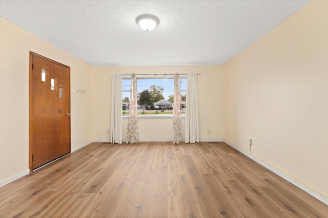 interior space featuring a textured ceiling and light wood-type flooring