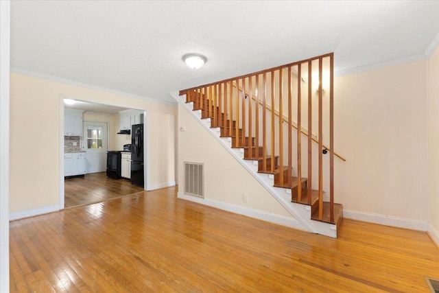 unfurnished living room with hardwood / wood-style flooring and ornamental molding