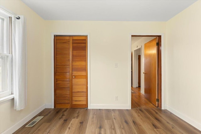 unfurnished bedroom featuring hardwood / wood-style flooring and a closet