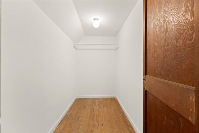 spacious closet featuring vaulted ceiling and hardwood / wood-style flooring