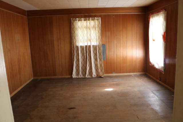 unfurnished room with hardwood / wood-style floors and wood walls