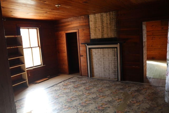 unfurnished living room featuring wood walls and wood ceiling