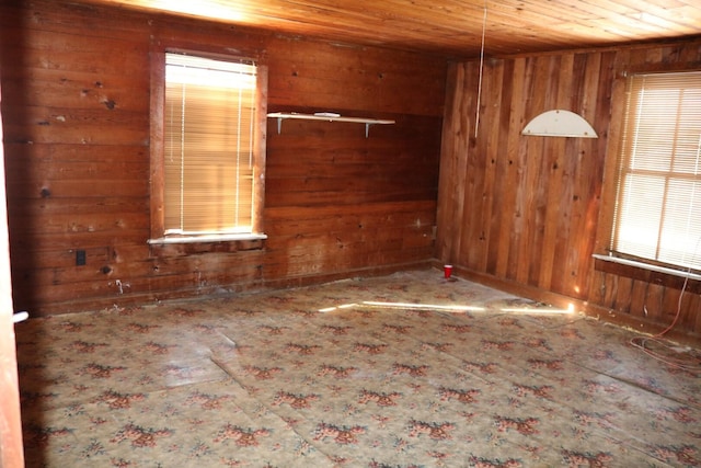 spare room featuring wooden walls and wood ceiling