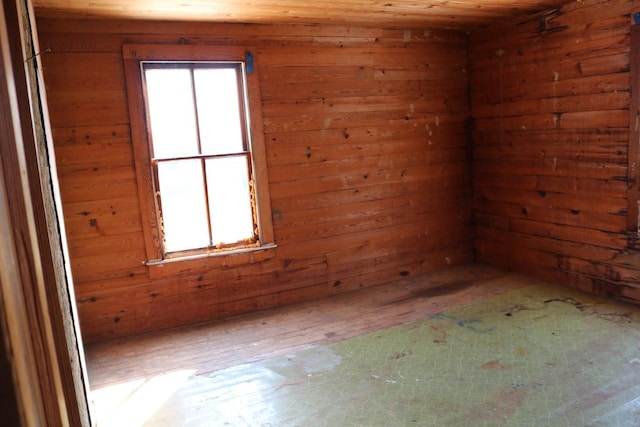 spare room featuring wood walls and wood ceiling