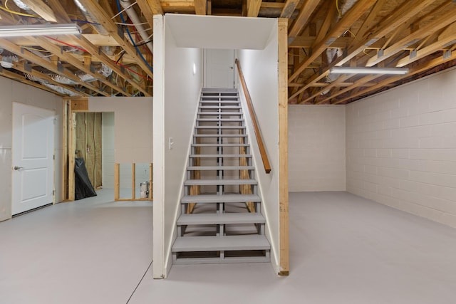 stairs featuring concrete flooring