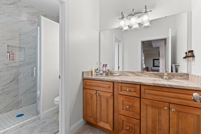 bathroom featuring vanity, toilet, and a shower with door