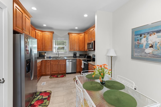 kitchen featuring light tile patterned flooring, sink, light stone countertops, and stainless steel appliances