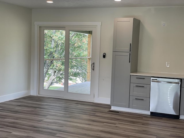 kitchen with baseboards, visible vents, dishwasher, dark wood-type flooring, and light countertops