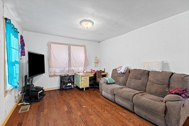 living room with baseboards, dark wood-type flooring, and visible vents