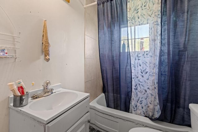 bathroom featuring toilet, vanity, and shower / bathtub combination with curtain