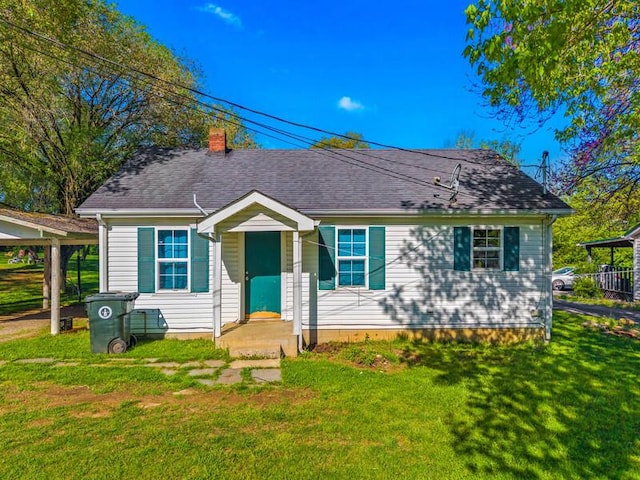 bungalow-style home featuring a chimney, a front lawn, and a shingled roof