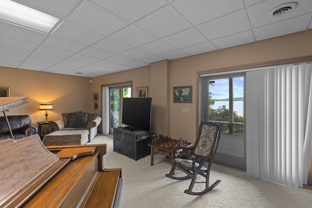 carpeted living room featuring visible vents and a paneled ceiling