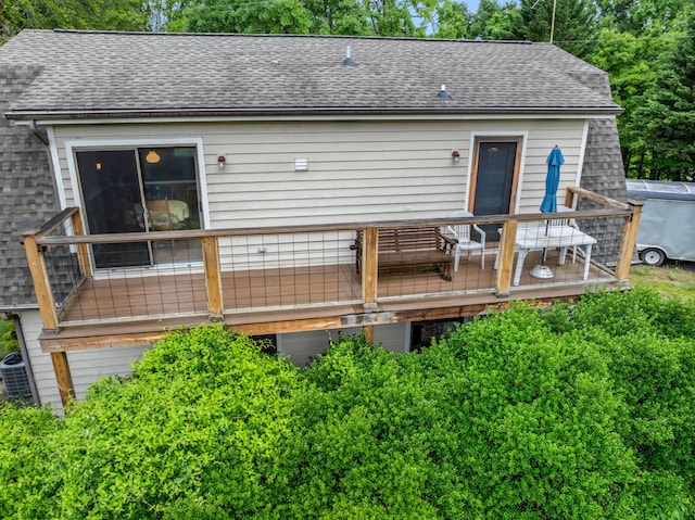 back of house with central air condition unit, a deck, and a shingled roof