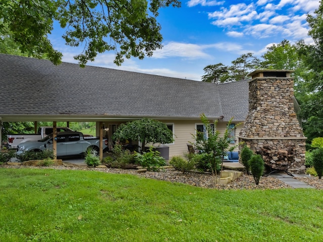 exterior space with roof with shingles, an outdoor stone fireplace, and a front lawn