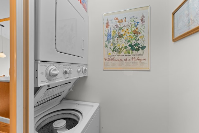 clothes washing area featuring stacked washer and dryer and laundry area