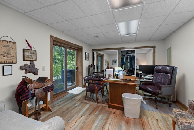 office space featuring a drop ceiling, light wood-type flooring, and visible vents