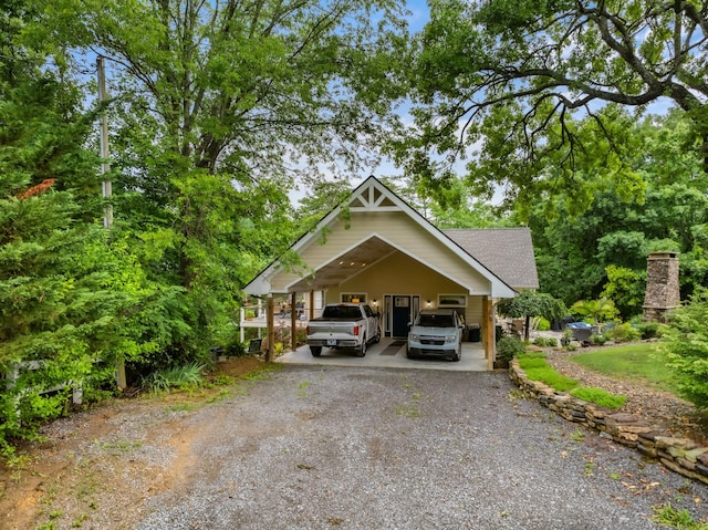 view of front of house featuring an attached carport, driveway, and a shingled roof