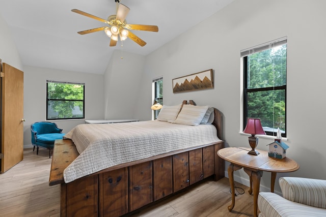 bedroom featuring ceiling fan, baseboards, lofted ceiling, and light wood-style flooring