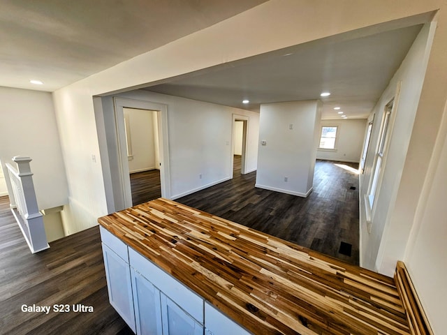 kitchen featuring dark hardwood / wood-style flooring, wood counters, and white cabinets