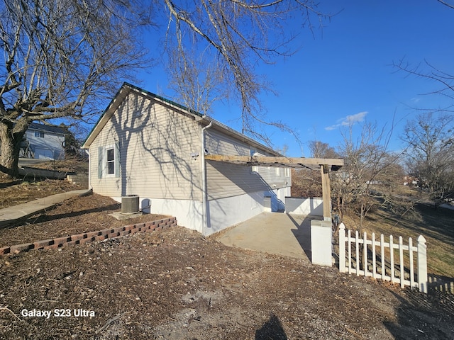 view of side of property with central AC unit and a patio area