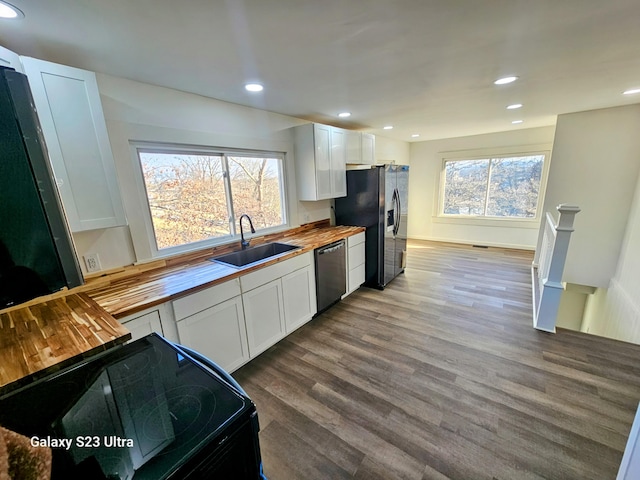 kitchen featuring appliances with stainless steel finishes, sink, white cabinets, and wood counters